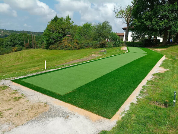 Tucson Outdoor tee line consisting of one continuous green synthetic grass strip surrounded by trees